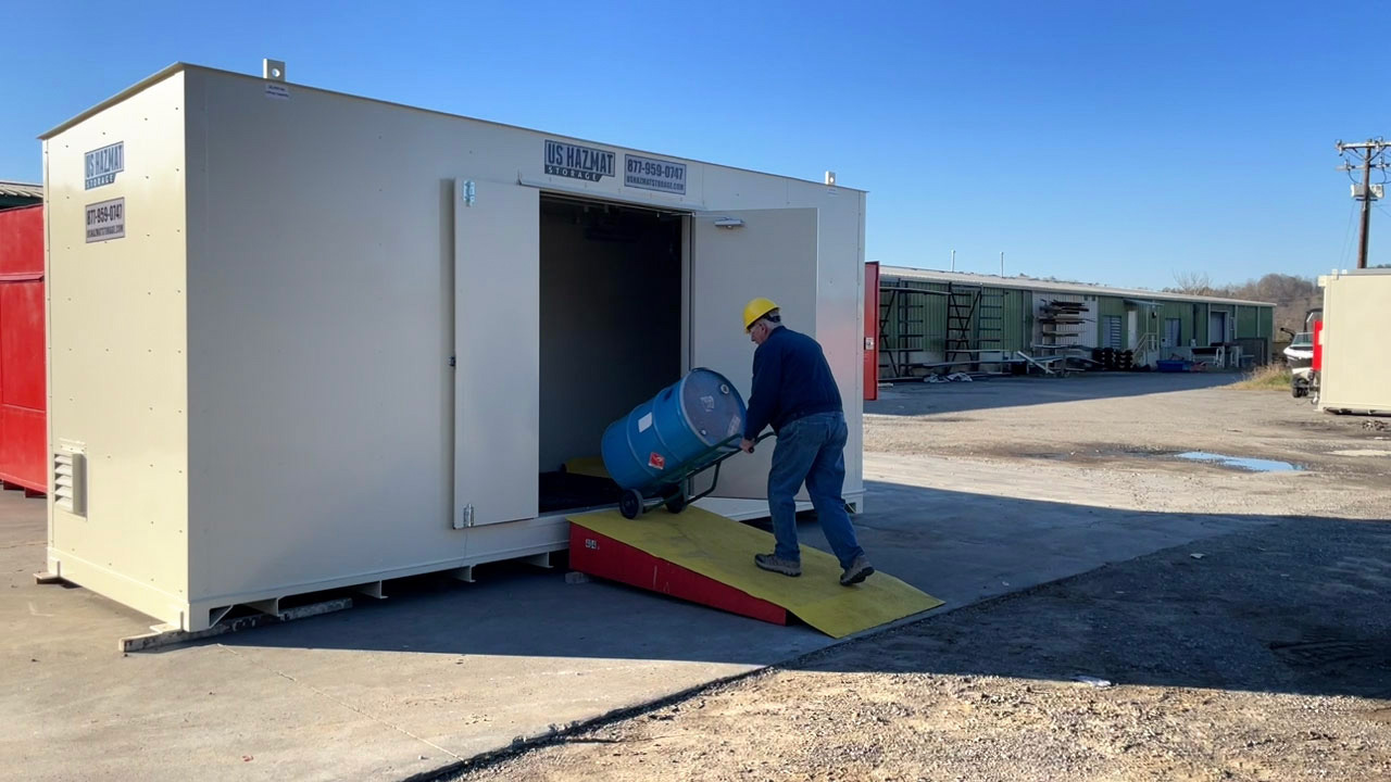Fire-rated US Hazmat chemical storage building installed on a customer site with doors open and drums inside